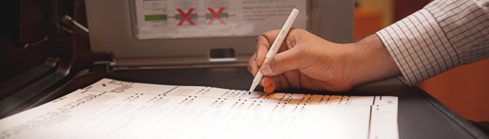 Voter marking a ballot in a voting booth