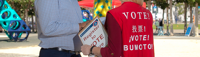 Elections Outreach staff at a park educating a San Francisco resident about registration options